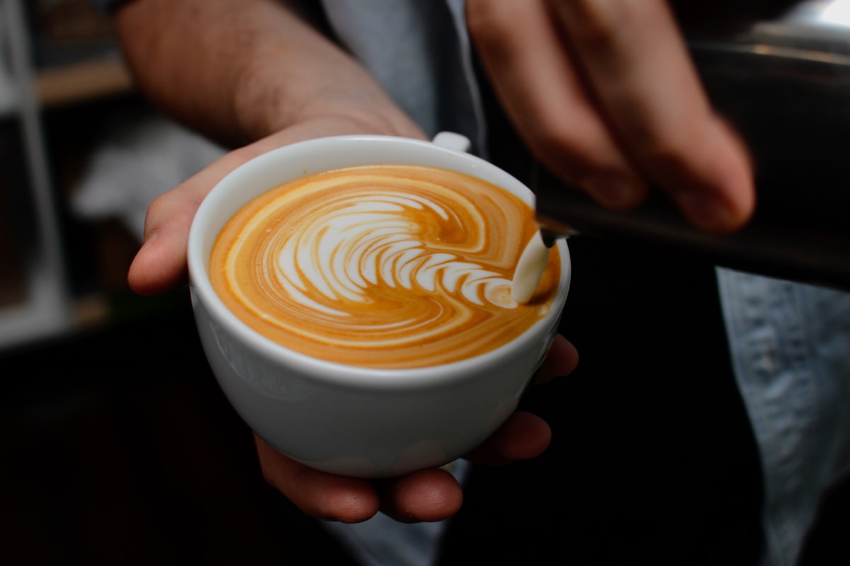 Latte art in a ceramic cup on a wooden table